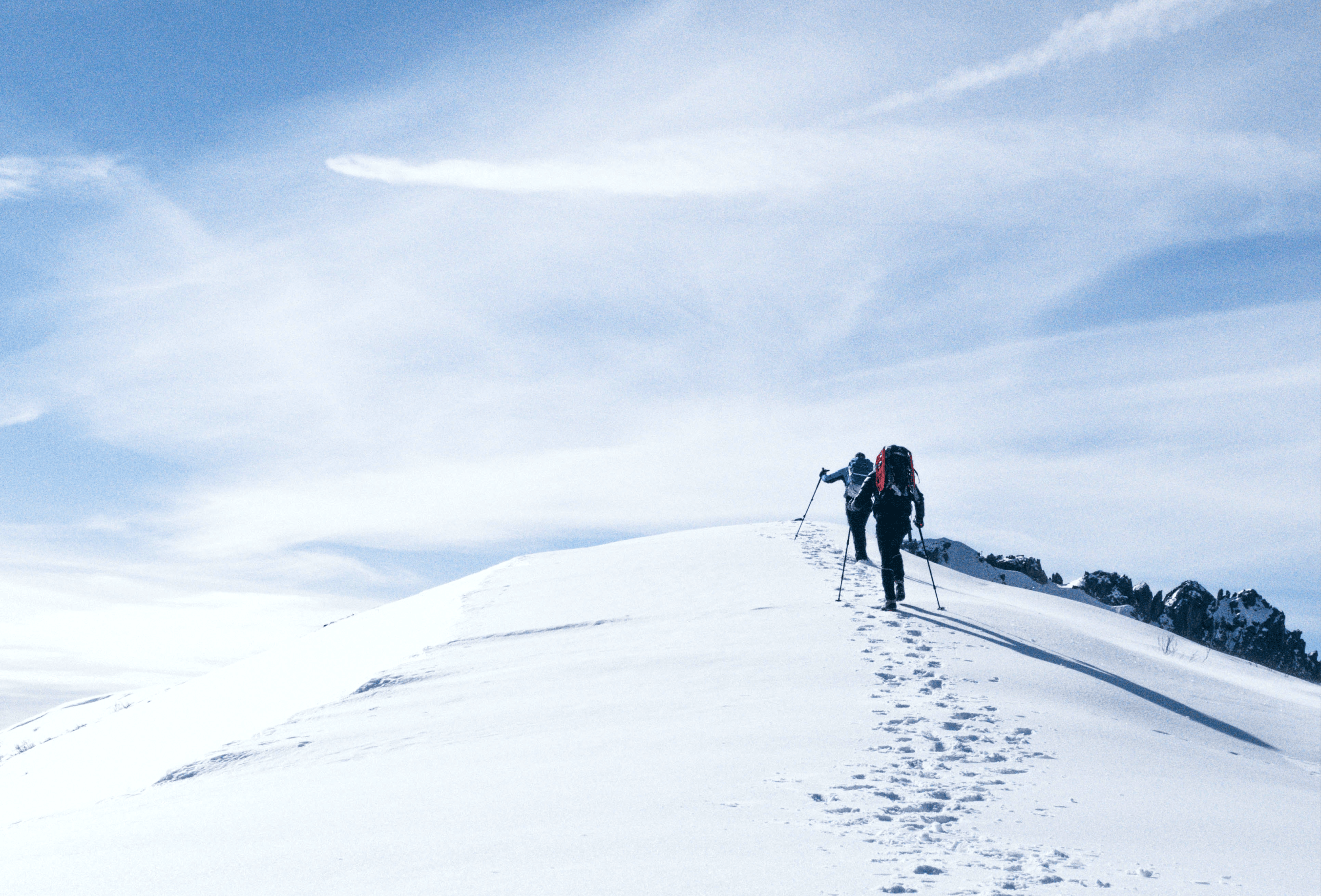 hikers climbing up a snowy hill